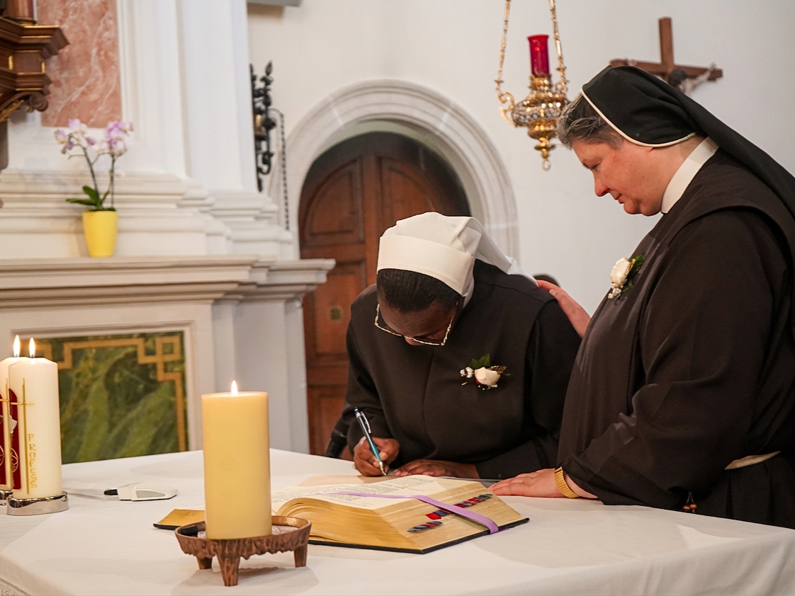 Sr. Elisabeth Kyalo trägt ihren Namen in ein Buch ein