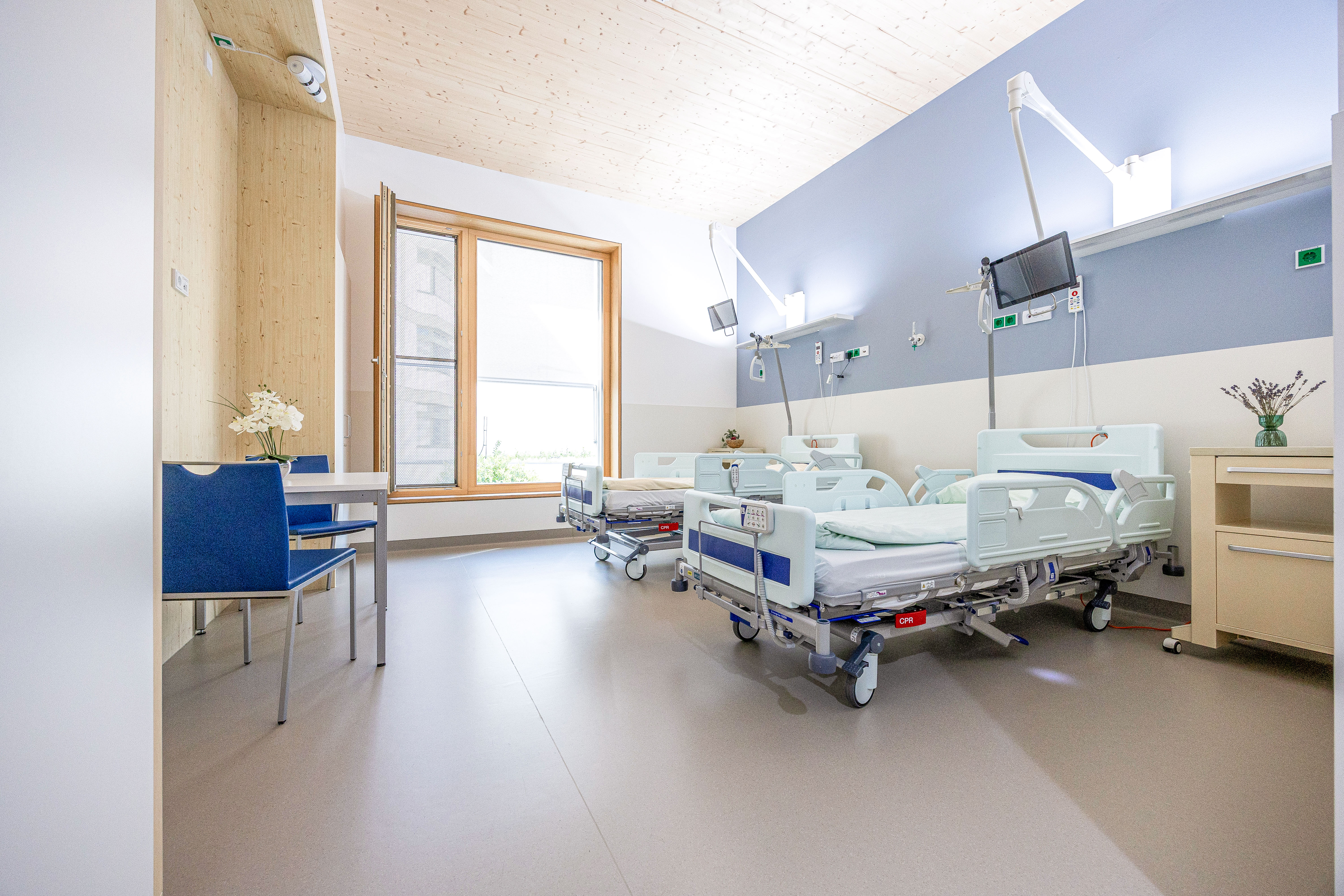 Ein modernes Patient:innenzimmer mit Holzelementen