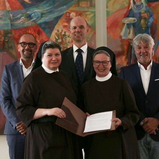 Die Geschäftsführung der Elisabethinen GmbH stehen vor zwei Kunstwerken.