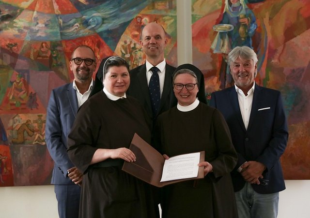 Die Geschäftsführung der Elisabethinen GmbH stehen vor zwei Kunstwerken.