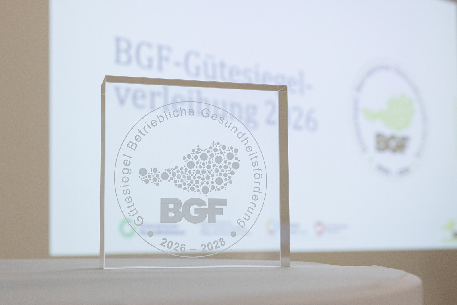 BGF Gütesiegel-Preis , im Hintergrund eine Leinwand mit dem BGF Logo